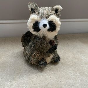 This is a raccoon holding a tiny acorn